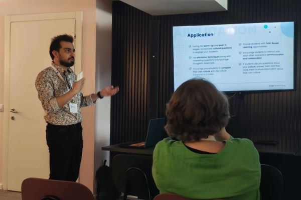 Umut presentando sobre coaching cultural en Business English frente a una audiencia durante la conferencia IATEFL BESIG en Malta.