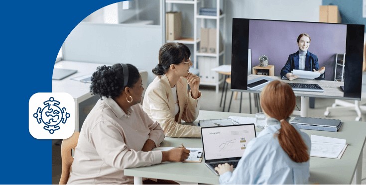 Equipo de trabajo en reunión híbrida con participante conectado por videollamada