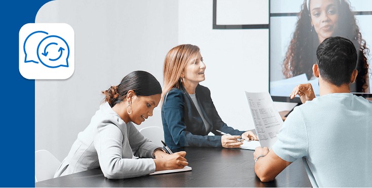 Equipo profesional participando en una reunión híbrida con videollamada, representando el desafío de comunicarse en inglés al retomar la rutina laboral. 