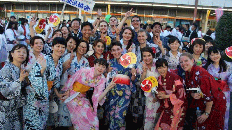 A BridgeTEFL grad teaching in Japan posing with her students in kimonos.