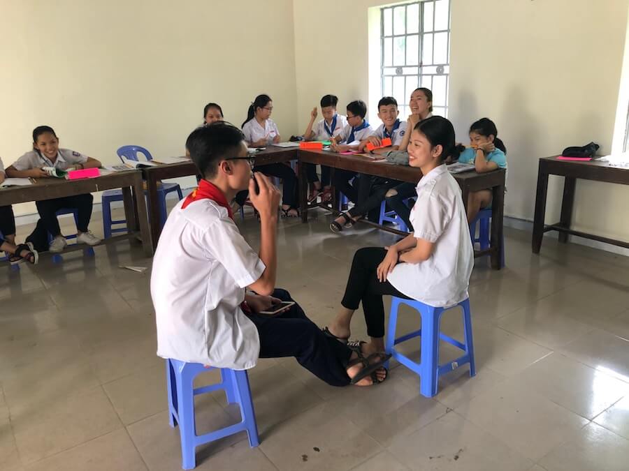 Teen ESL students play a game of charades.