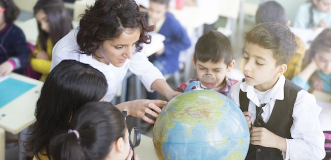 Teacher with students looking at globe