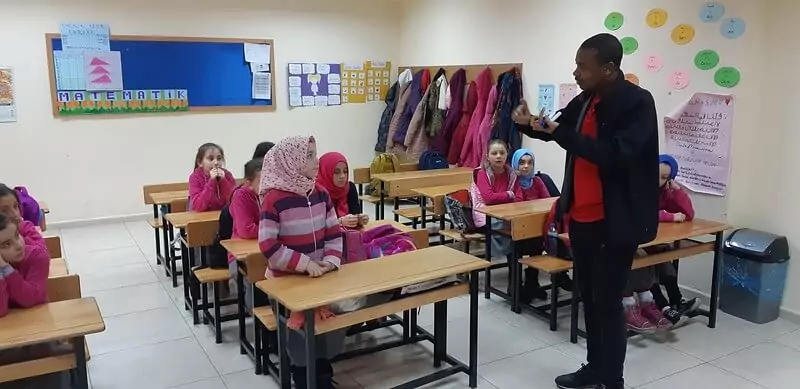 A teacher explains the rules before starting a speaking activity in a girls-only classroom.