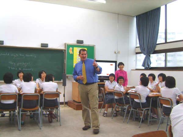 An EFL teacher playing a game with young students in Asia.