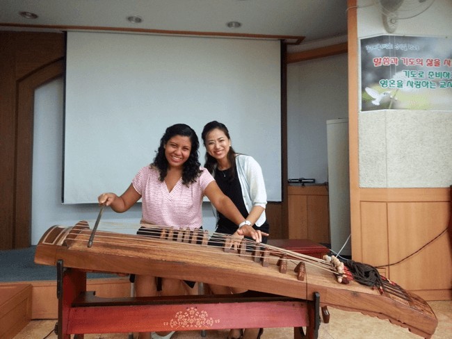 Gedisa, English teacher in Korea, receives a lesson on the "gayageum,” a traditional Korean instrument