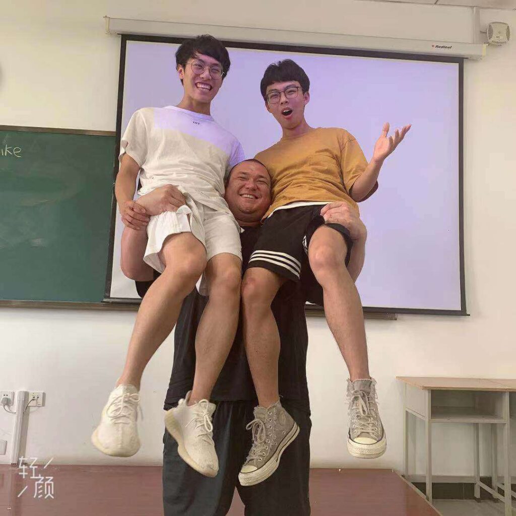 teacher lifting students in the air