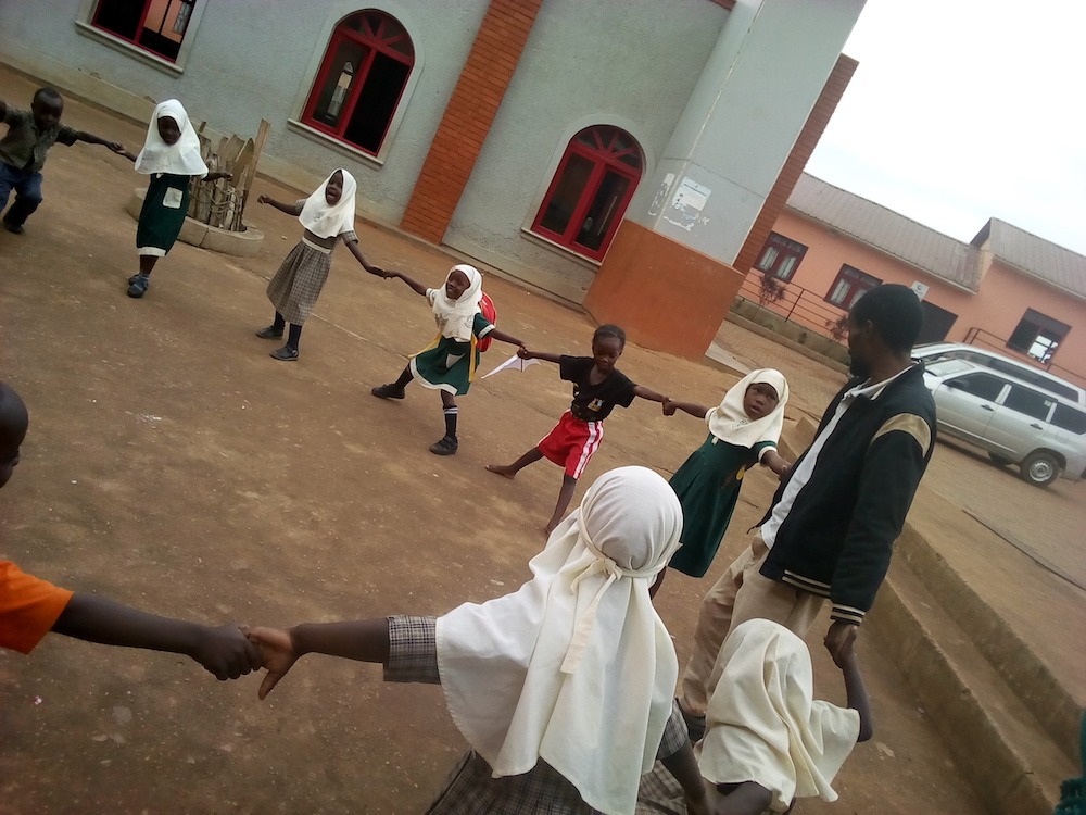 Ugandan teacher, Badiru, playing with his students in the schoolyard