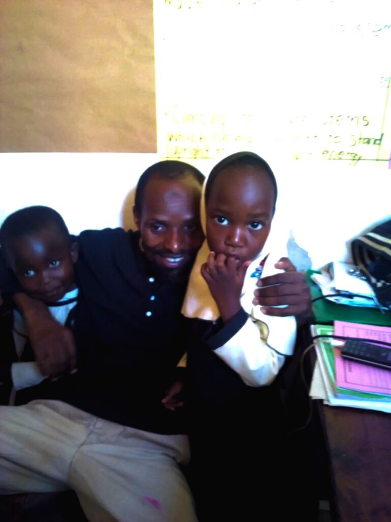 teacher Badiru with two young students