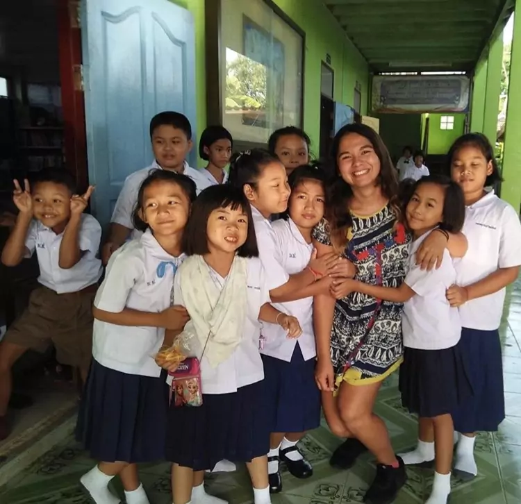 An image of Brenda, an ESL teacher from the U.S., with her students in Thailand