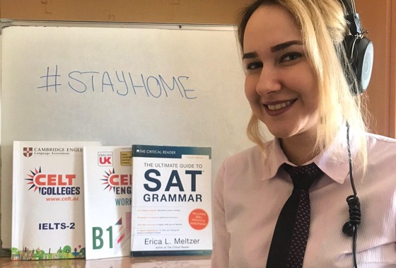 English teacher Nasim standing by exam prep textbooks.  