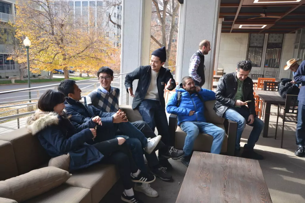 An image of a group of ESL students chatting in English while sitting on a sofa at a cafe