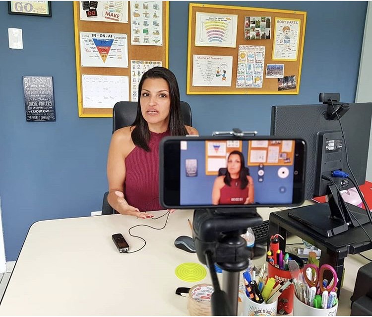 An image of an online English teacher describing her goals in front of a web cam.