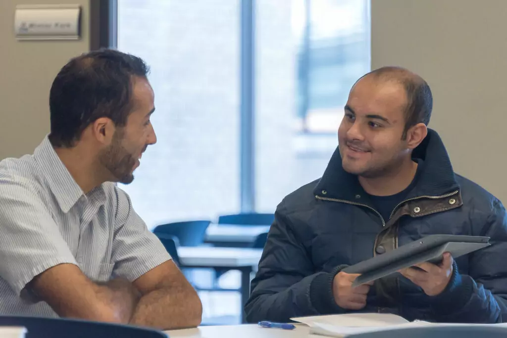 An image of two English students engaging in an interactive speaking activity during an English class