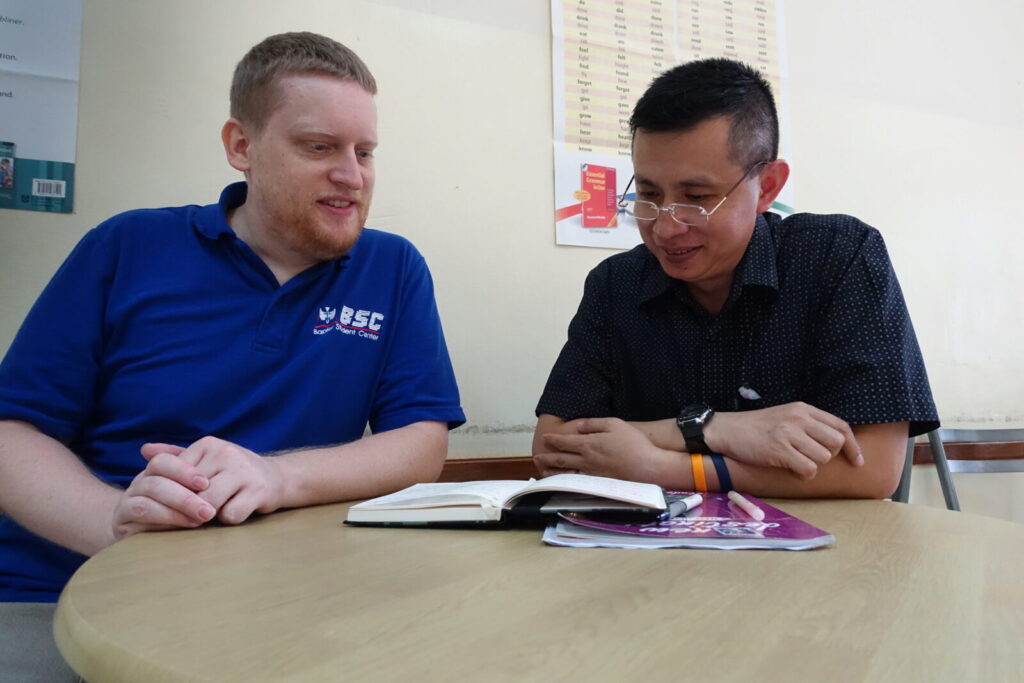 Brandon, from the U.S., tutoring one of his adult students in Thailand.