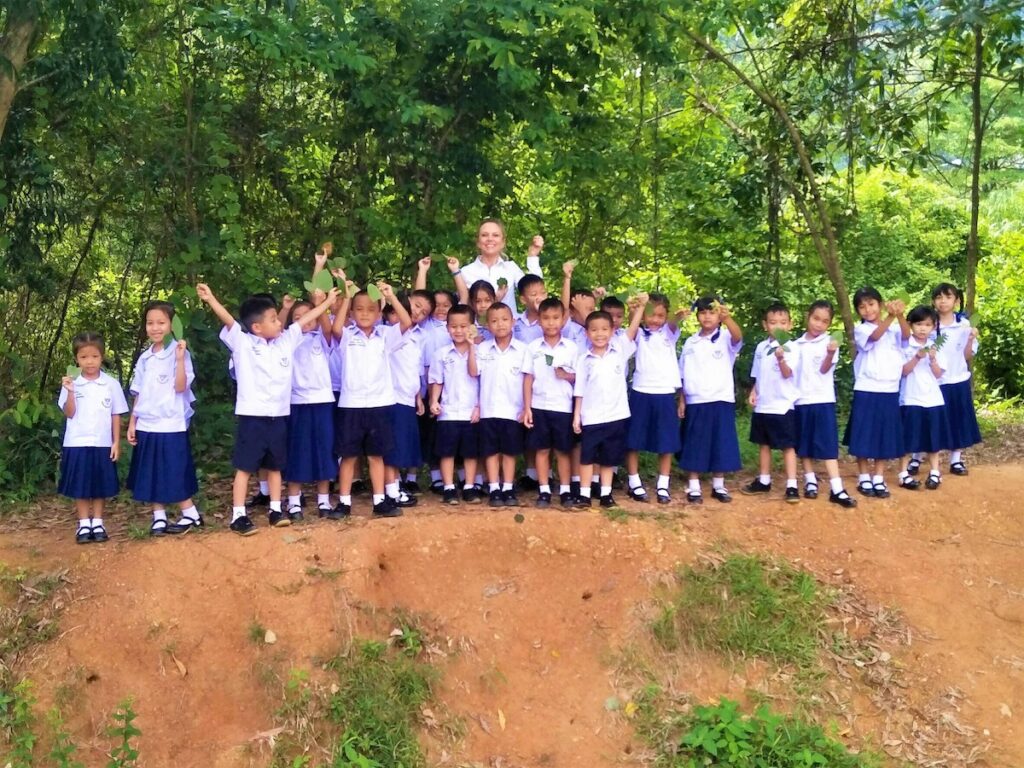 young students engaged in outdoor play with their teacher.