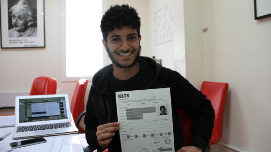 A student poses with the results of his IELTS English language test.