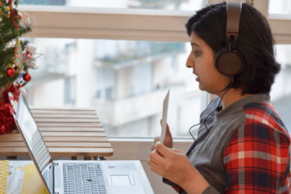 An image of Suchismita, a Bridge TEFL graduate and independent English teacher, teaching an online English lesson, holding a flashcard up to the camera