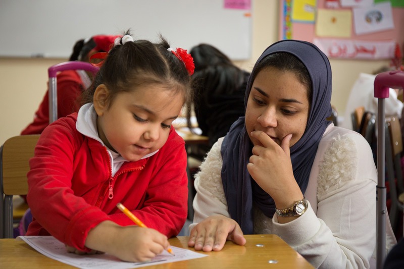 Teacher encourages young ESL learner with positive feedback and error correction
