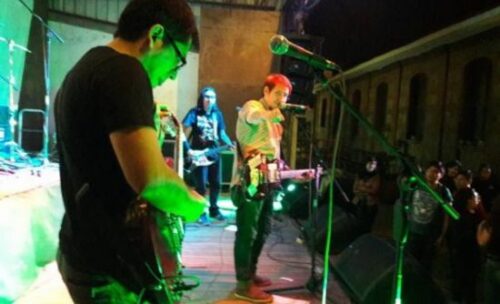 Vinicius (vocalist) performing with his band onstage. 