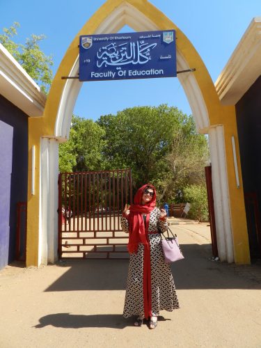 ESL teacher Andrea in Sudan posing in front of the University of Khartoum.