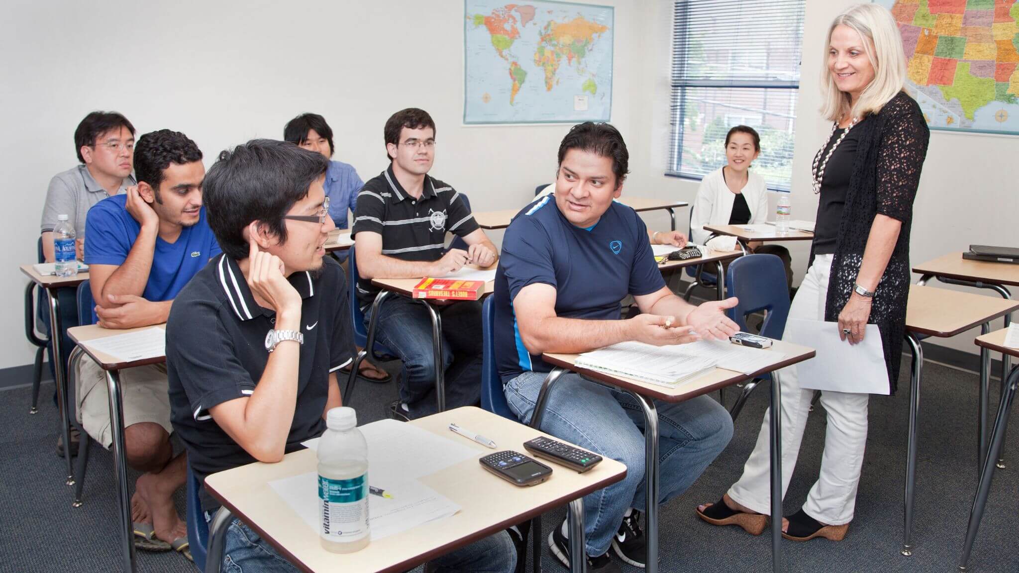 an ESL teacher leads a discussion with her adult students.
