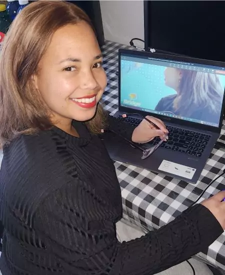 Bridge alum, Kaylynn, sitting in front of her laptop.