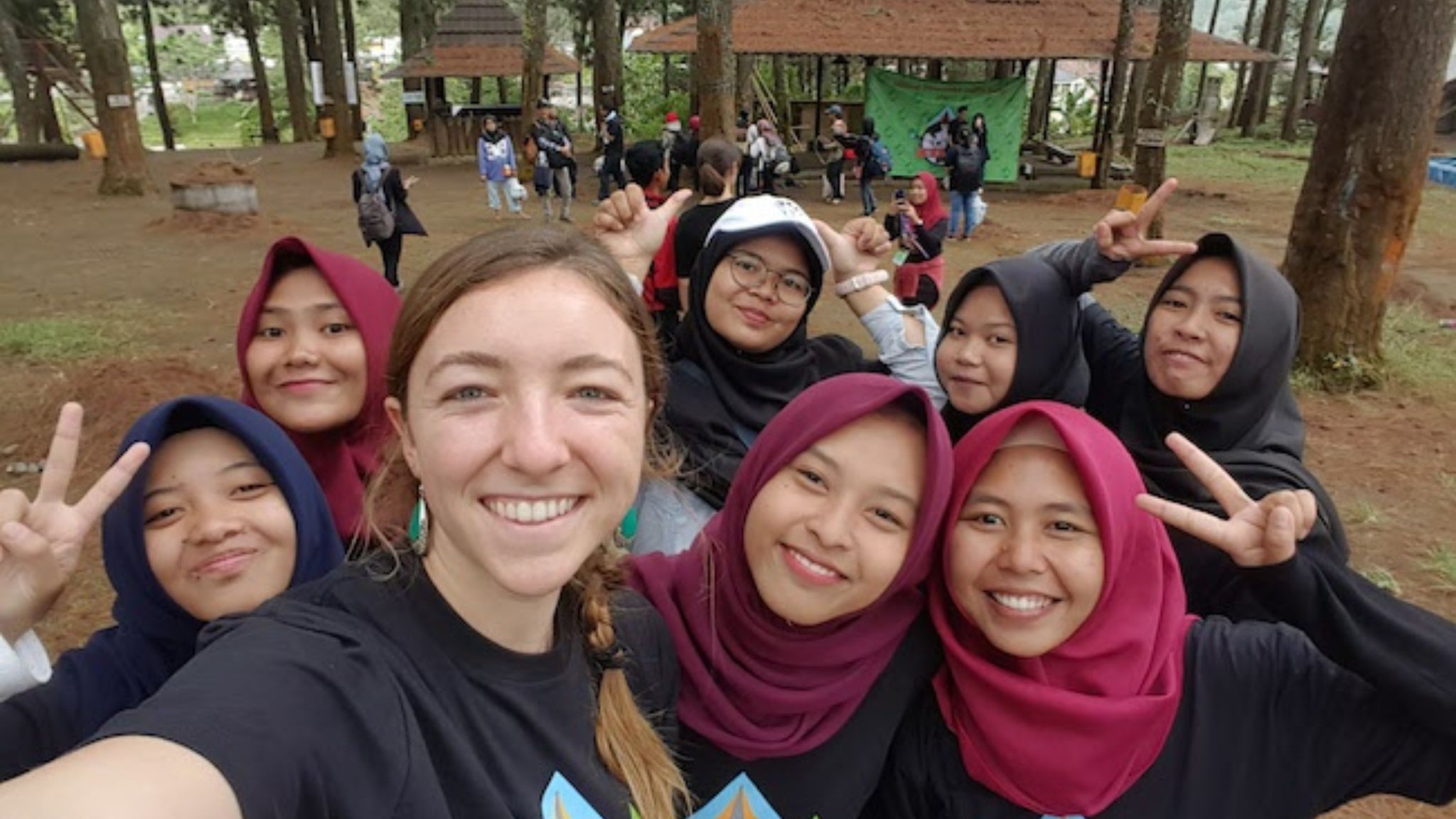 a teacher poses with her students in Indonesia.