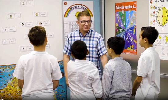 a teacher explaining a lesson to four teen students