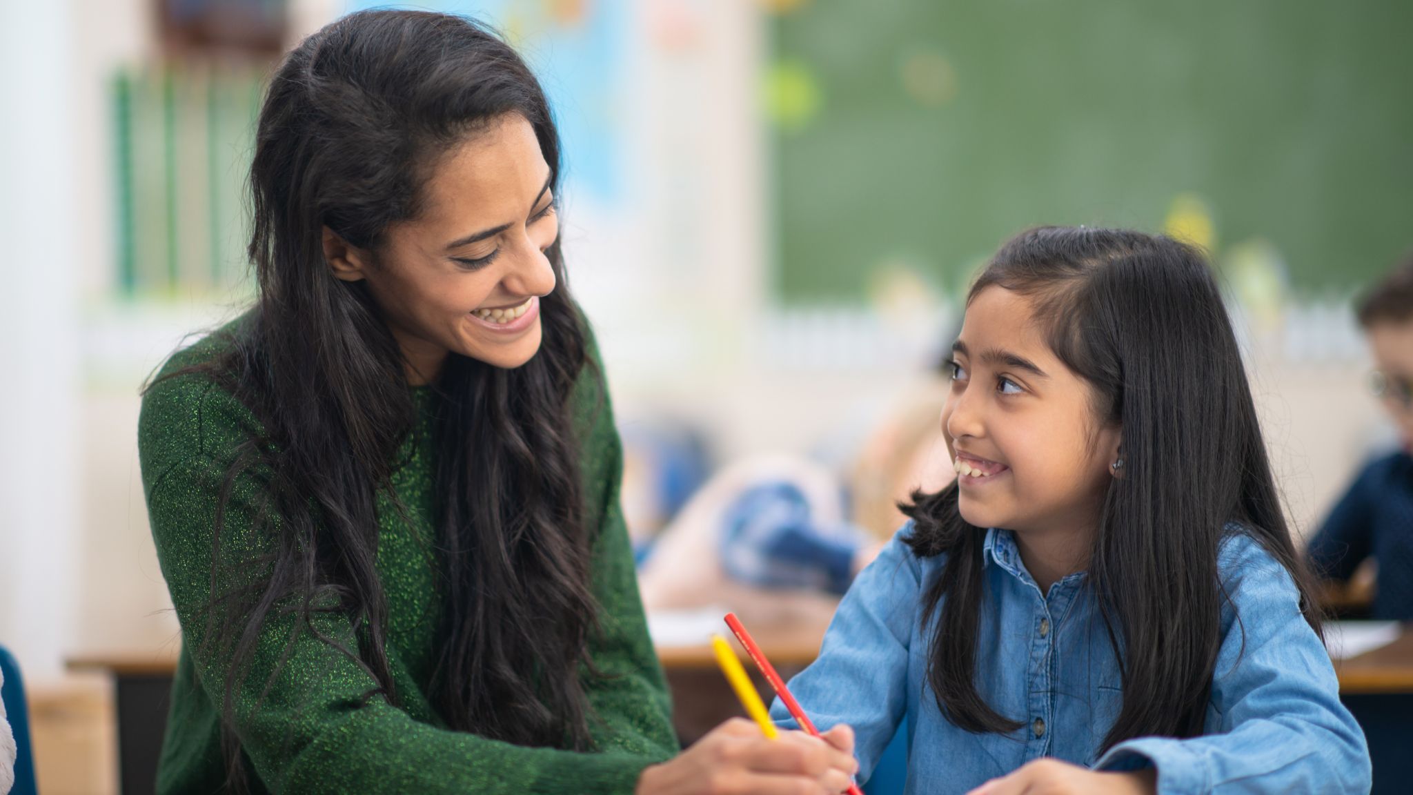 a teacher and young student smiling at one another