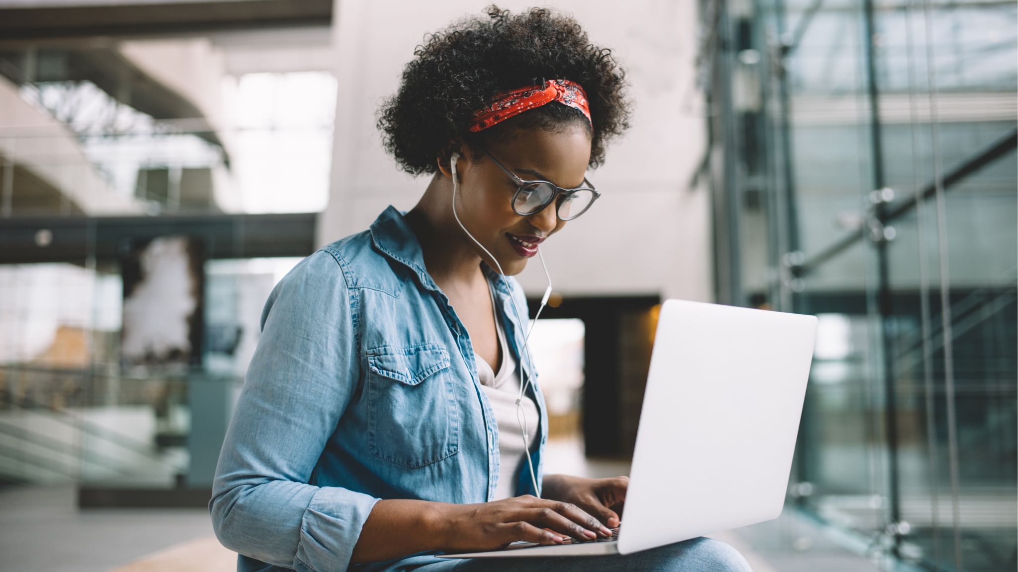 You woman at a corporate office engaged in work on her laptop