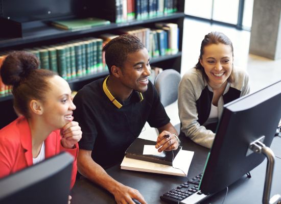 young adult students working online together on a shared computer