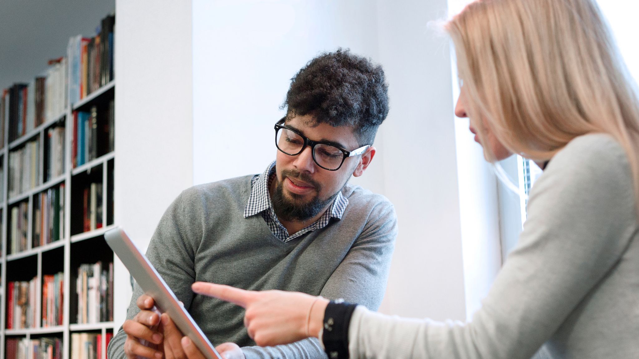 a teacher shows an adult student progress on a tablet