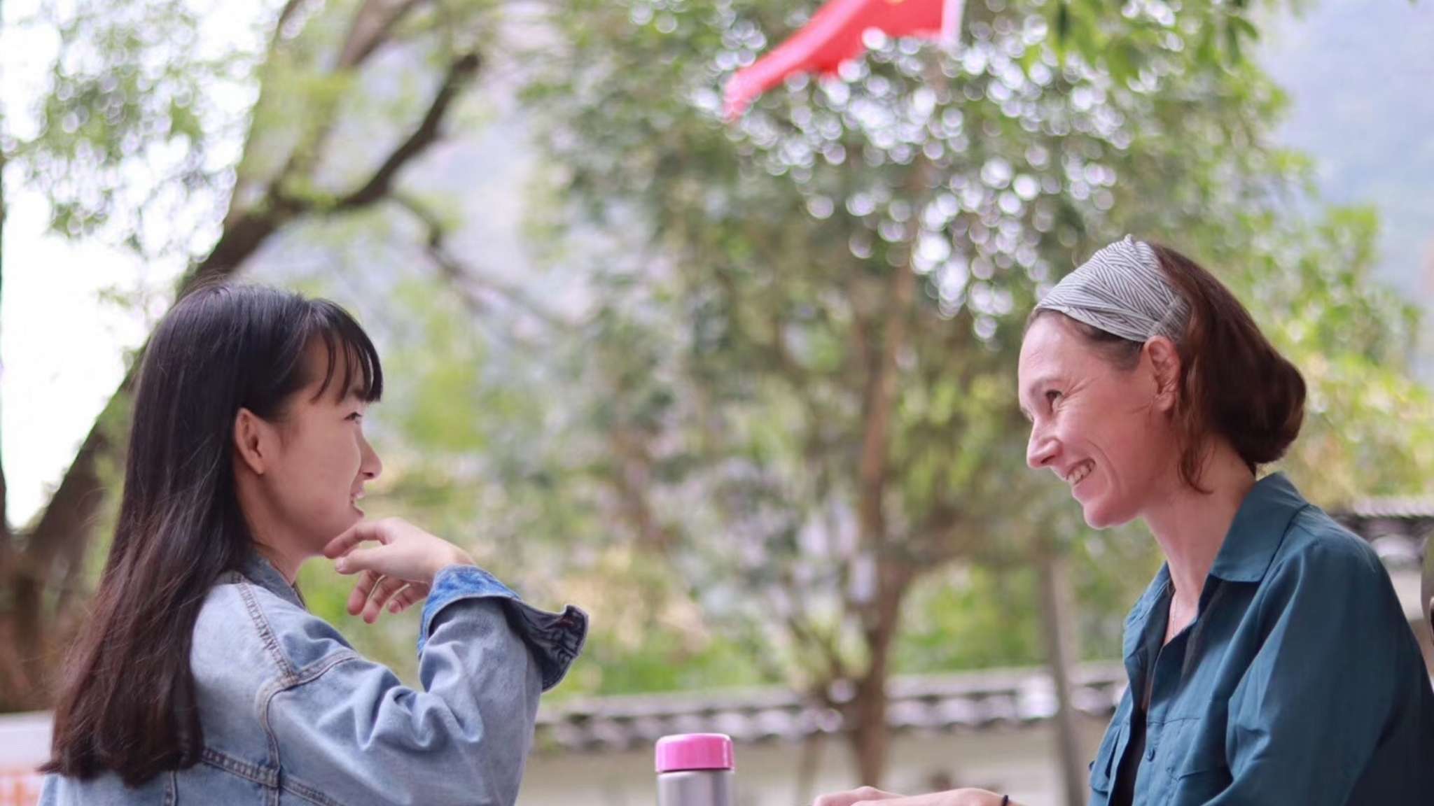 An image of two adults having a conversation in an outdoor setting