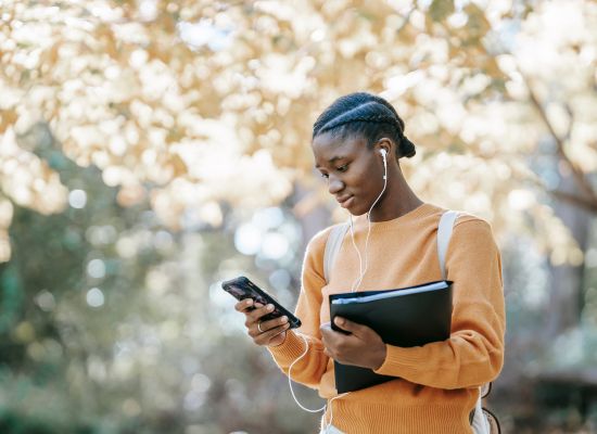 a student listening to an audiobook and looking at their phone