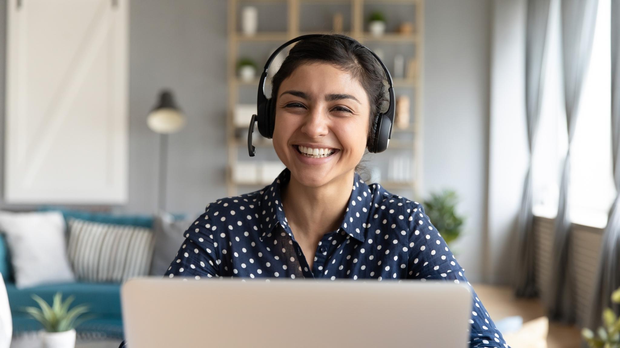 An image of a woman attending an online conference from a home office