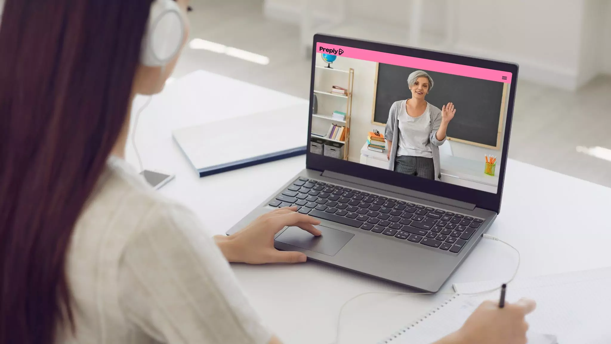 An image of a student looking at their English teacher on the screen of a laptop