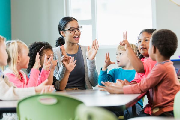 An image of a teacher with a group of students sitting around a table