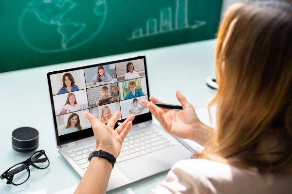 An image of a woman teaching English to a group of students online