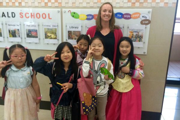 An image of Katie, a Bridge alumna, with her students teaching English in South Korea