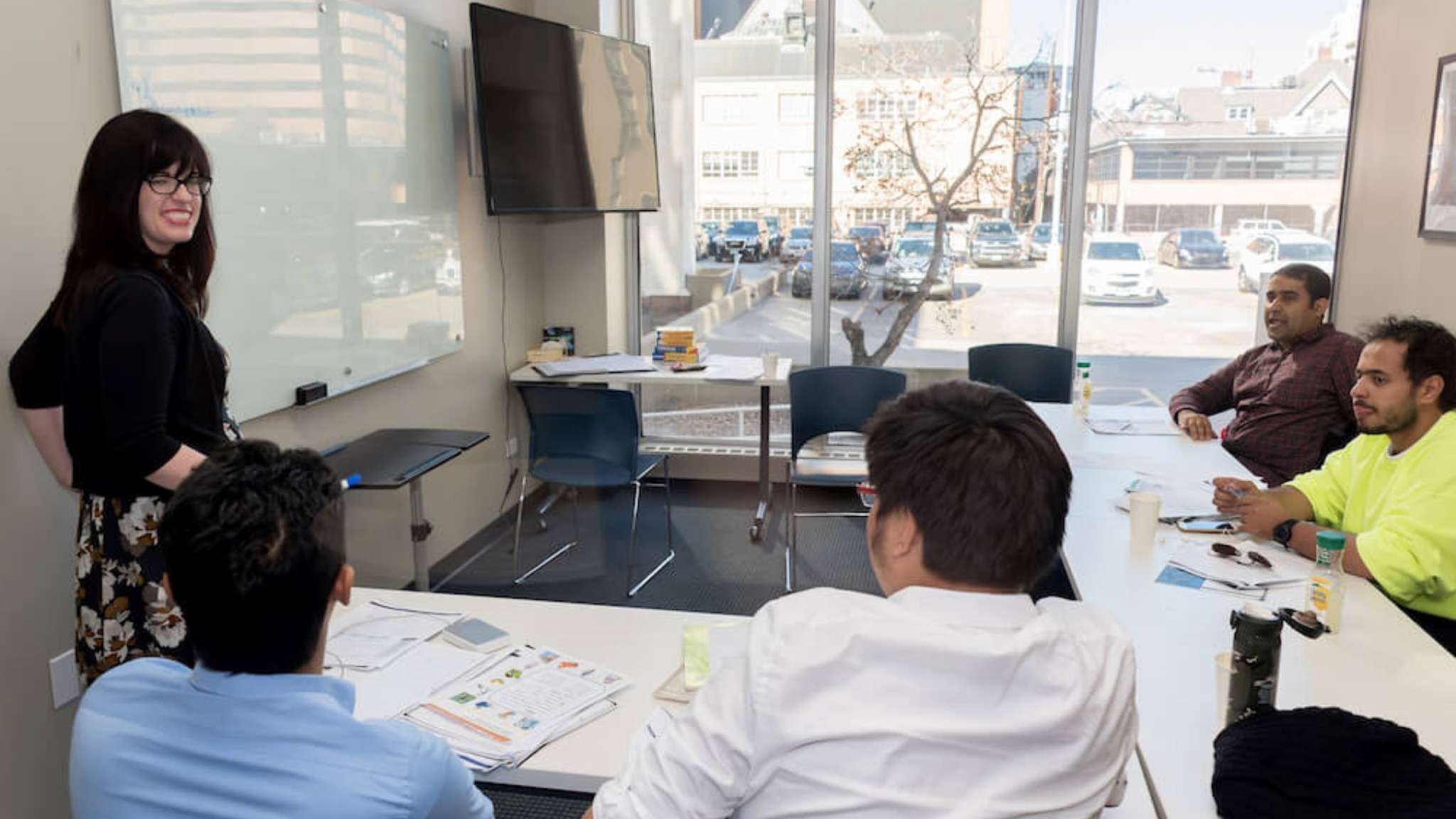 An image of an English teaching teaching a classroom of adult students