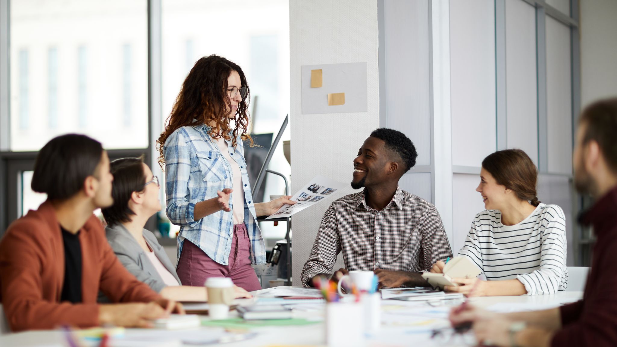 An image of a diverse business team sitting around a table, having a meeting