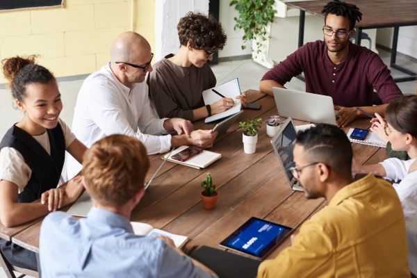 An image of a diverse team sitting around a table having a meeting