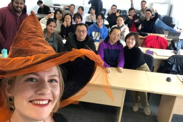 An image of a Bridge Teacherpreneur Academy smiling with a group of her English students in a classroom