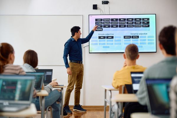 An image of an English teacher using a smart board to teach vocabulary, representing educational technology