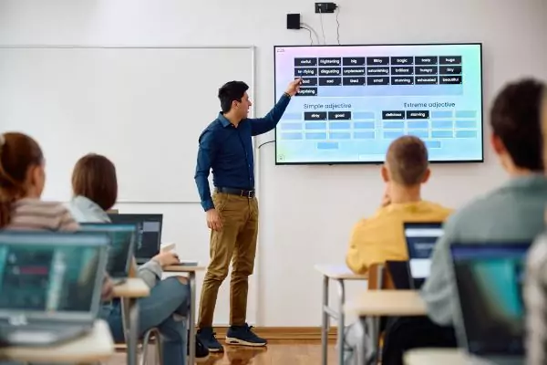 An image of an English teacher using a smart board to teach vocabulary, representing educational technology