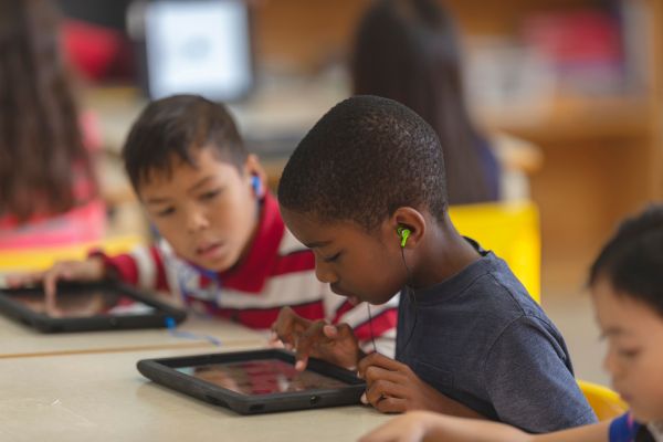 An image of two students using tablets in the classroom to represent digital pedagogy