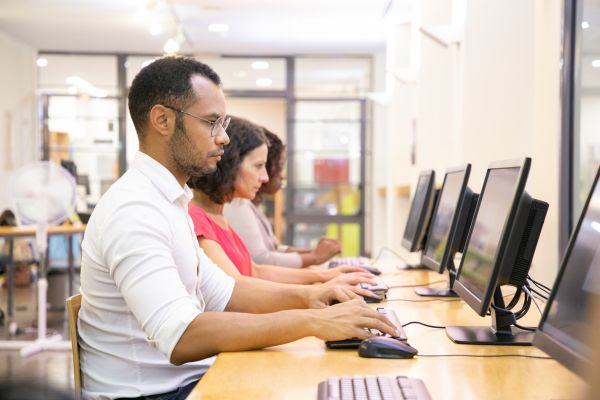 An image of adult ESL learners taking an online English proficiency exam