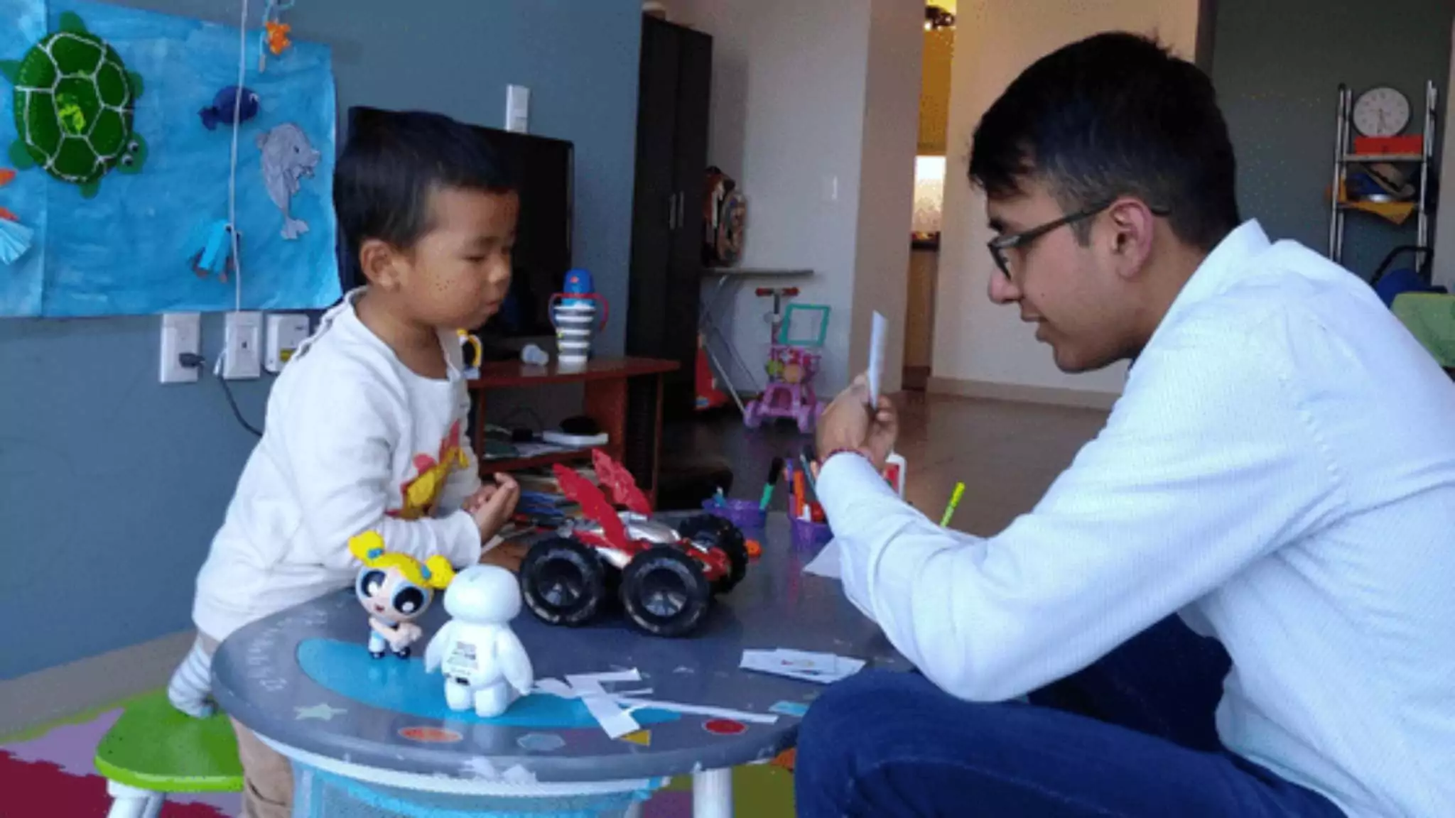 An image of an English teacher playing a game with his student