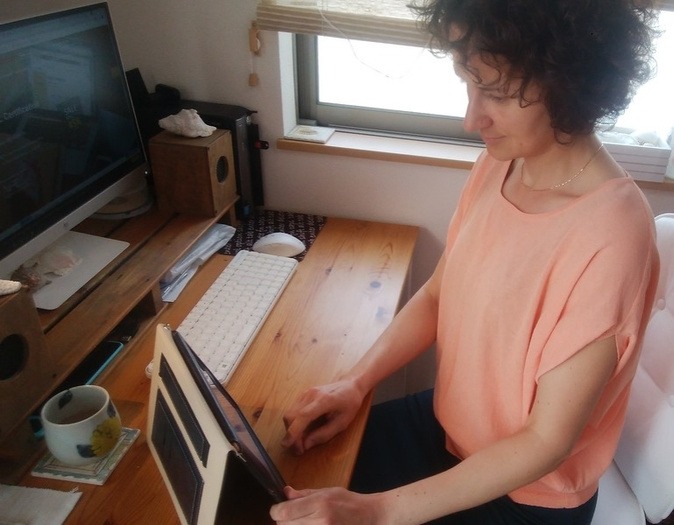 Johanna, an online English teacher based in Japan, prepares lessons on her tablet from her home workspace.