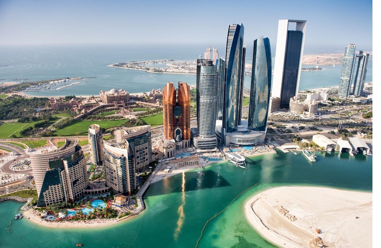 Part of Abu Dhabi, UAE with tall buildings and surrounding area viewed from a helicopter.